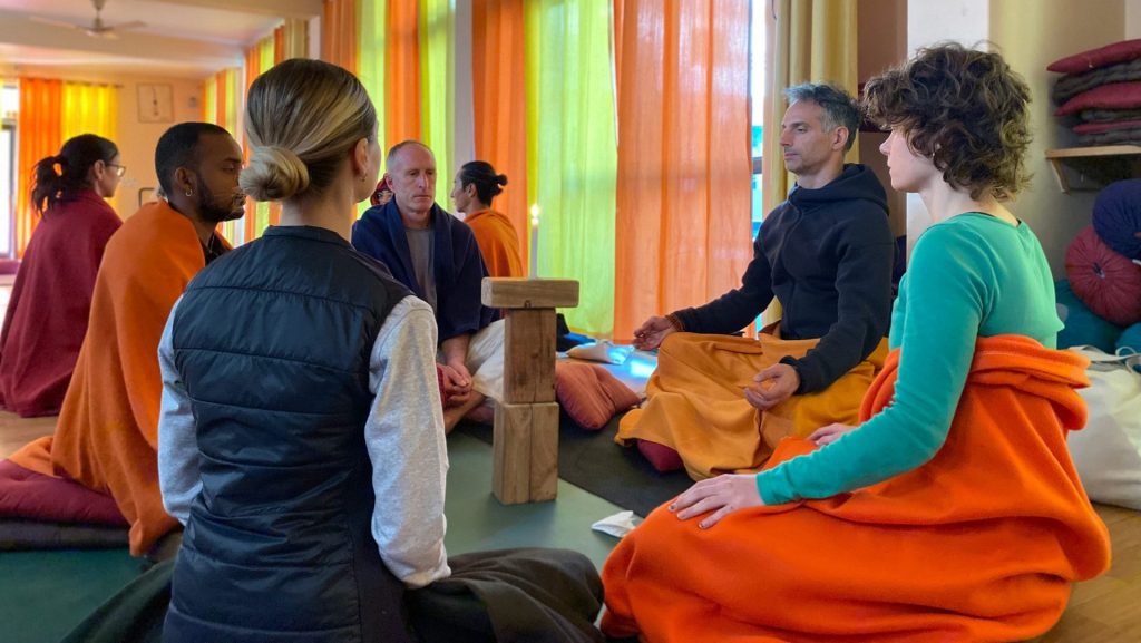 People are meditating in a sunny and colorful room.