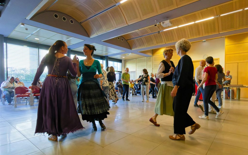 People dancing and socializing in a large, bright room.